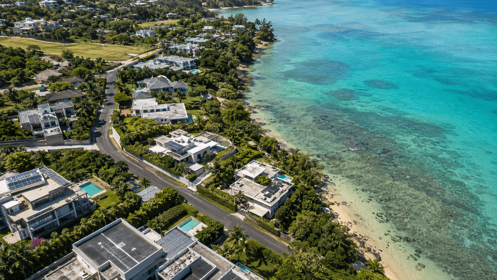 Aerial view of a coastal residential area in Mauritius with villas, tropical greenery and a turquoise lagoon